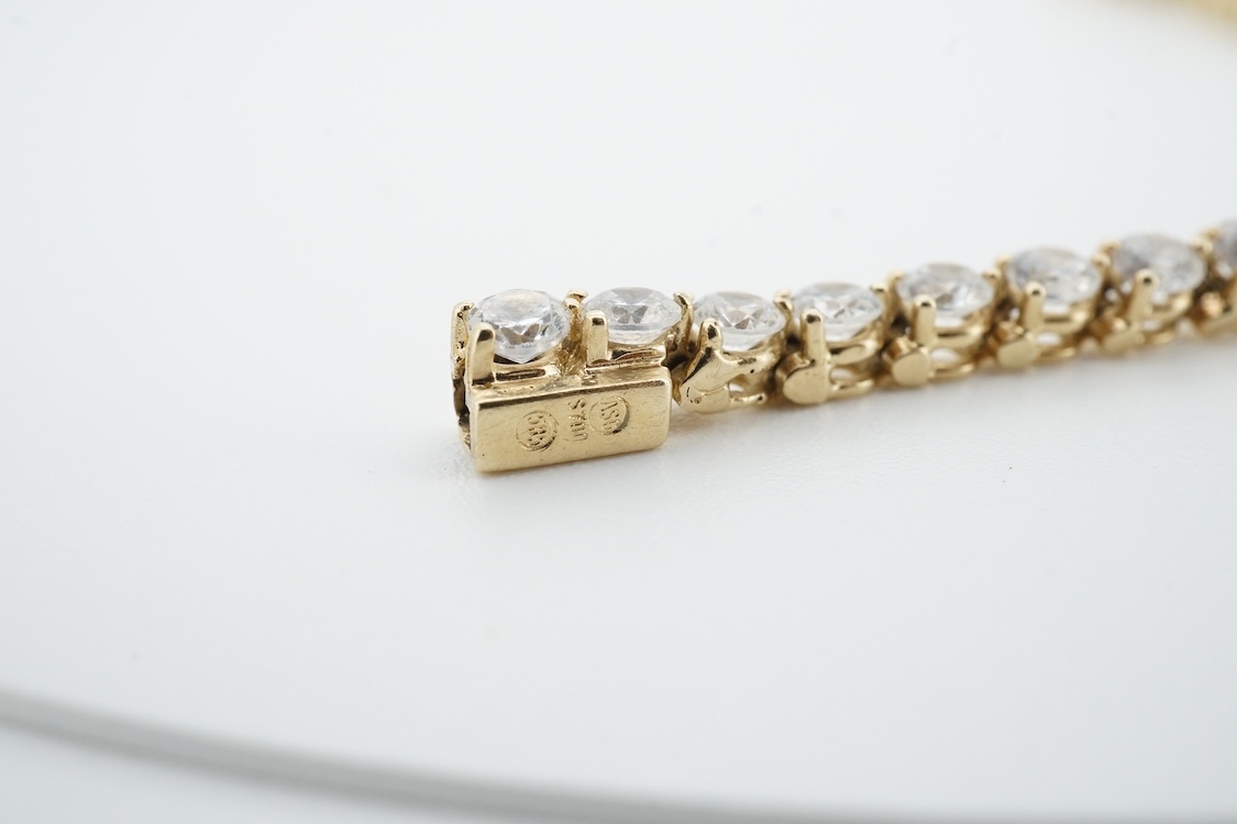 A modern yellow metal (stamped 585) and cubic zirconia set line bracelet, 18cm and a pair of similar drop earrings, together with a similar 9k and cubic zirconia set cluster ring, size N.